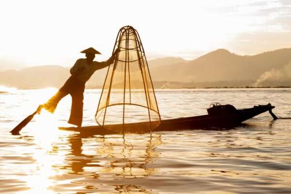 Photo d'un pêcheur Intha au coucher du soleil sur le lac Inle au Myanmar Birmanie en Asie